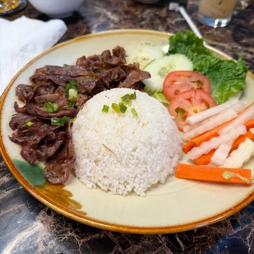 Viet Holic's Vietnamese grilled beef with rice, pickled carrots, daikon, and fresh vegetables.